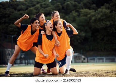 Cheerful women's soccer team celebrating victory and shouting on playing field. - Powered by Shutterstock