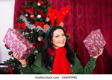 Cheerful Xmas Woman With Reindeer Ears Showing Two Christmas Gifts