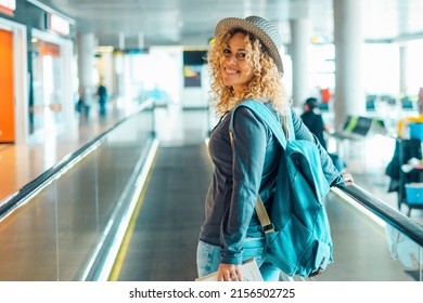 Cheerful Young Adult Woman Travel At The Airport With Backpack. Female People Portrait Smiling And Walking At The Gate. Pretty Blonde Lady Traveler Enjoy Trip And Holiday Vacation Leisure Activity