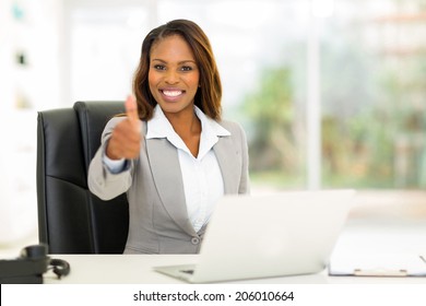 cheerful young African businesswoman giving thumb up