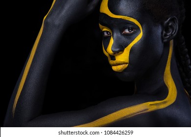 Cheerful young african woman with art fashion makeup. An amazing woman with black and yellow paint makeup