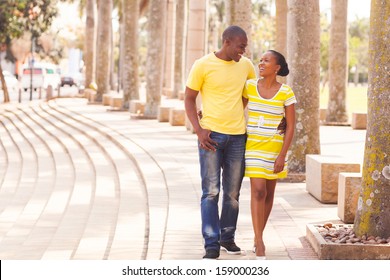 cheerful young afro american couple walking on urban street - Powered by Shutterstock