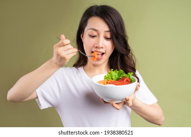Cheerful Young Asian Girl Eating Health Food On Background