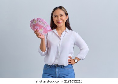 Cheerful Young Asian Woman Holding Money Banknotes And Looking At Camera Isolated Over White Background