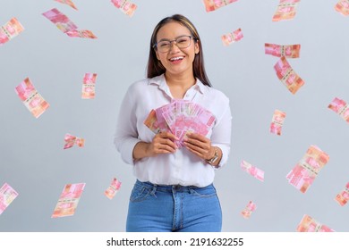Cheerful young Asian woman holding money banknotes isolated over white background - Shutterstock ID 2191632255
