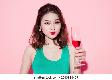 Cheerful Young Asian Woman Raising Glass Of Wine