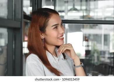 Cheerful young Asian woman smiling in living room. - Shutterstock ID 1096013459
