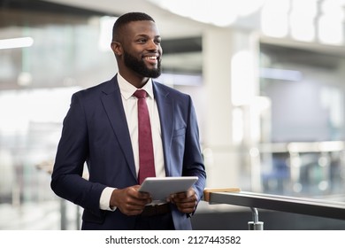 Cheerful young black bearded man manager walking by office building corridor, holding modern digital tablet, using mobile app for business, looking at copy space and smiling, panorama - Powered by Shutterstock