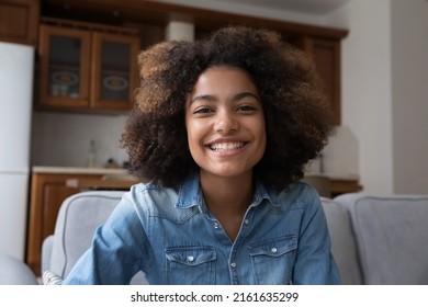 Cheerful Young Black Woman Video Blogger Sitting On Couch Streaming Live Looking At Web Camera Broadcasting On Web Channel Recording Clip. Webcam Selfie Portrait Smiling Teen Female Making Video Call