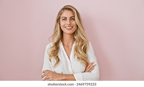 Cheerful young blonde woman standing confidently with arms crossed, expressing joy and happiness over a pink isolated background! - Powered by Shutterstock