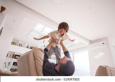 Cheerful Young Boy Having Fun With Father On Sofa