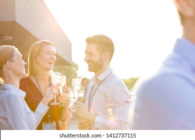 Cheerful Young Business Colleagues Talking While Standing At Rooftop Party