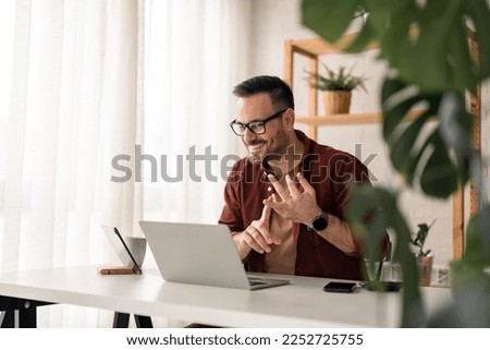 Cheerful young businessman employee, HR manager having remote online work hybrid meeting or distance job interview, gesturing with hands during virtual video conference call in home office.