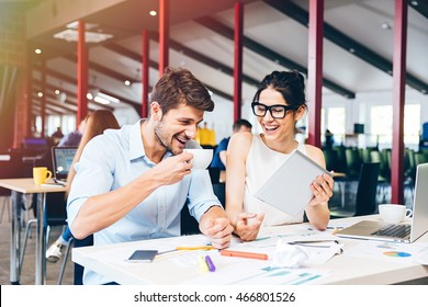 Cheerful Young Businesspeople Laughing And Working In Office Together