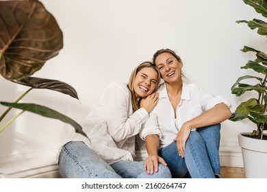 Cheerful young caucasian women laughing looking at camera hugging each other on white background. Blondes wear casual clothes at home. Concept of enjoying moment - Powered by Shutterstock