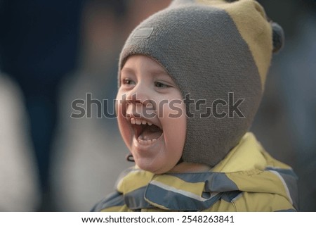 Similar – Image, Stock Photo Child laughing joyfully while making a snow angel, dressed in a vibrant winter coat and hat