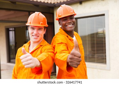 Cheerful Young Construction Workers Thumbs Up Outside The House