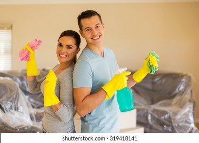 Cheerful Young Couple Cleaning Their New House