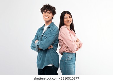 Cheerful Young Couple Crossing Hands In Confident Gesture Smiling To Camera Standing Back To Back Over White Studio Background. Happy Friendship And Love Relationship Concept - Powered by Shutterstock