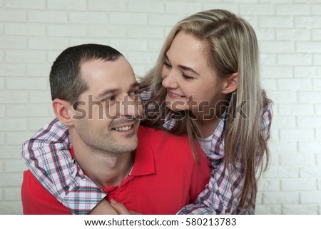 Cheerful young couple at home. Woman and man hugs and kisses at home.