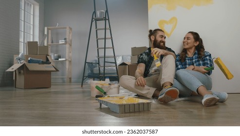 Cheerful young couple in the morning at home. Newlywed caucasian couple are relaxing during renovation of their new home and positively smiling - new life, mortgage concept - Powered by Shutterstock