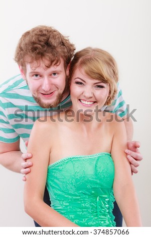 Cheerful young couple portrait blonde girl and bearded guy on gray background,