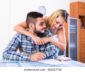 Cheerful Young Couple At The Table Filling Forms For Joint Banking Account
