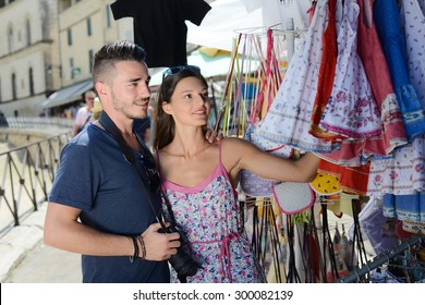 Cheerful Young Couple Visiting Europe Buying At Souvenir Shop