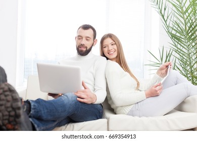 Cheerful young couple working on laptop.
