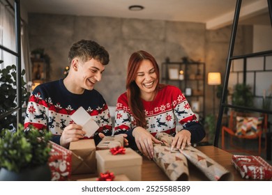 A cheerful young couple wrap a holiday gift with red and brown paper, surrounded by festive decorations, capturing the joyful spirit of Christmas in a cozy living room - Powered by Shutterstock