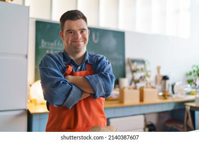 Cheerful young Down Syndrome waiter working in take away restaurant, social inclusion concept. - Powered by Shutterstock