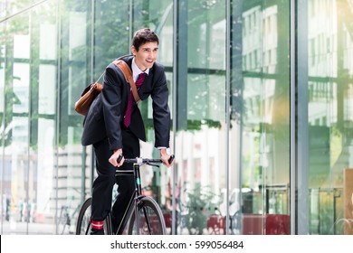 Cheerful Young Employee With A Healthy Lifestyle Riding An Utility Bicycle To A Modern Workplace In Berlin