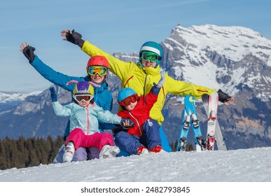 A cheerful young family of four, equipped for skiing, enjoys a winter activity moment on the mountain - Powered by Shutterstock