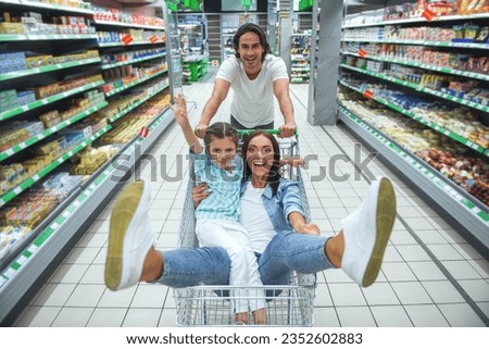 Similar – Image, Stock Photo Mother pushing shopping cart with her infant baby boy child down department aisle in supermarket grocery store. Shopping with kids concept.