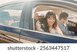 Cheerful young family is preparing for family trip by car. Caring parents fasten their seat belts. Caring for safety while traveling on the road. Concept of tourism and road trip.