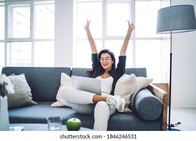 Cheerful young female in casual clothes and eyeglasses sitting on sofa and resting after working on remote project on laptop in cozy living room - Shutterstock ID 1846246531