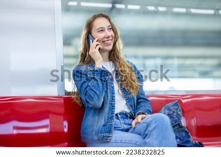 Cheerful young female traveling, standing in MRT train station. Enjoying travel. Caucasian traveler woman traveling by Mass Rapid Transit(MRT) train using smartphone. Transportation, travel concept.