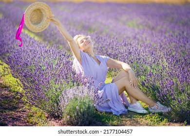 Cheerful young girl hands up, holding straw hat illuminated by sunset sun in Lavender field. Beautiful blonde smiling woman enjoying aromas and journey to travel on vacation, outdoors. Aromatherapy - Powered by Shutterstock