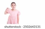 Cheerful young girl points to cheek with a smile in a pink dress, stand against isolated white background. Playful and positive mood, perfect for themes related to happiness childhood self expression