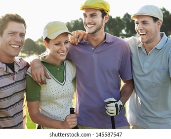 Cheerful young golfers with arms around on golf course