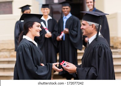 Cheerful Young Graduate Receiving Diploma From Dean