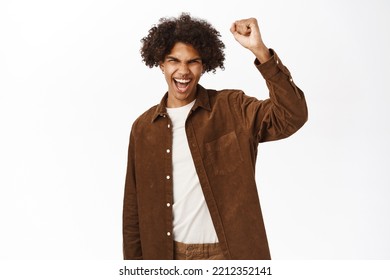 Cheerful Young Guy, 20 Years Old, Raising Fist, Staying United, Protesting Or Chanting, Standing Over White Background