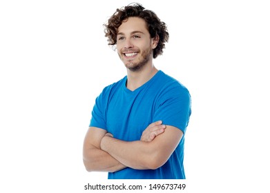Cheerful young guy posing with folded arms