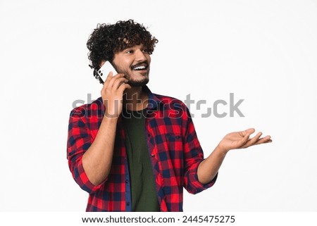 Cheerful young Indian freelancer having mobile conversation on cellphone isolated over white background. Hindi man talking on the cellphone with relatives friends colleagues customers