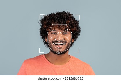A cheerful young Indian man with curly hair poses for facial recognition analysis in a relaxed indoor setting.