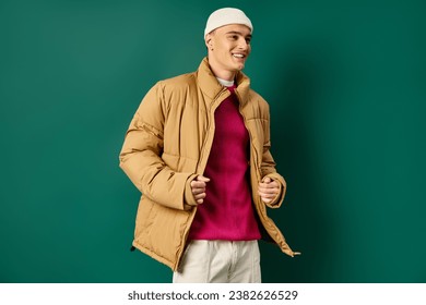 cheerful young man in beanie hat and stylish puffer jacket on turquoise background, winter trends - Powered by Shutterstock