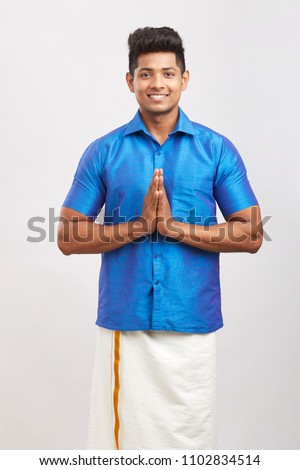 Cheerful young man greeting traditional wear
