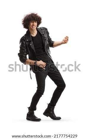 Cheerful young man in a leather jacket pretending to play a guitar isolated on white background