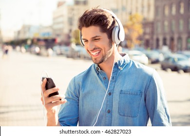 Cheerful Young Man Listening To Music With Headphones