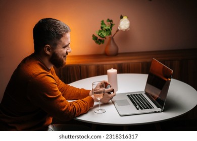 Cheerful young man making video call using laptop computer presenting ring and making remote marriage proposal sitting at table. Loving boyfriend making distant proposal for marriage, marry me. - Shutterstock ID 2318316317